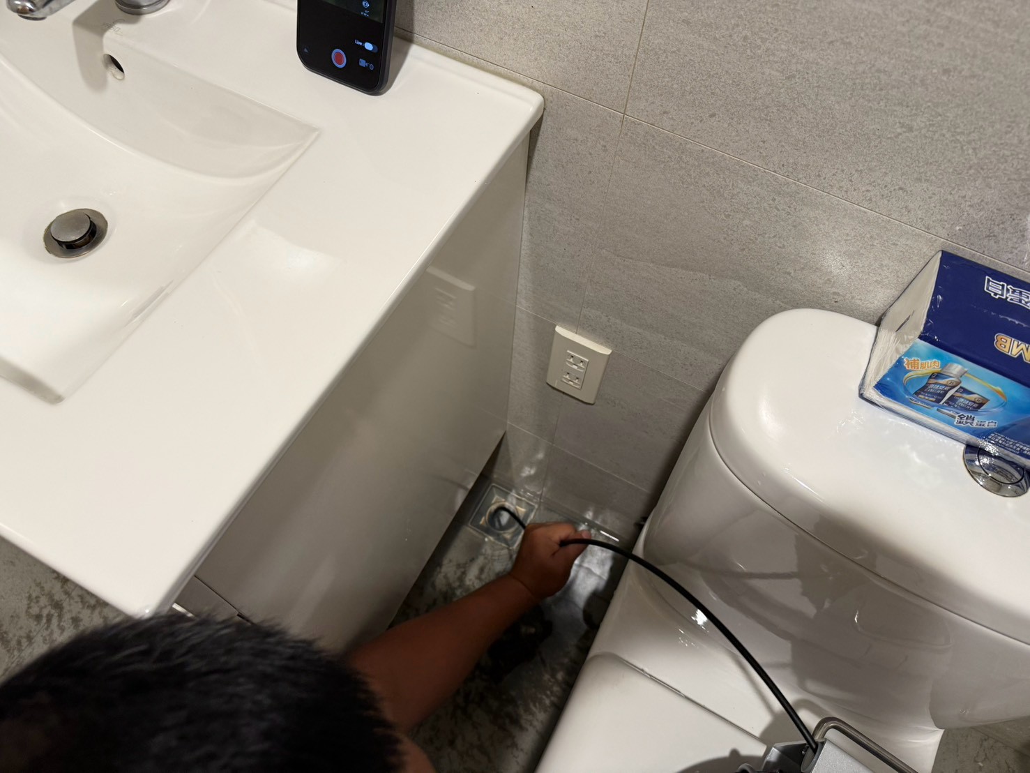 施工人員檢查管線與內視鏡螢幕