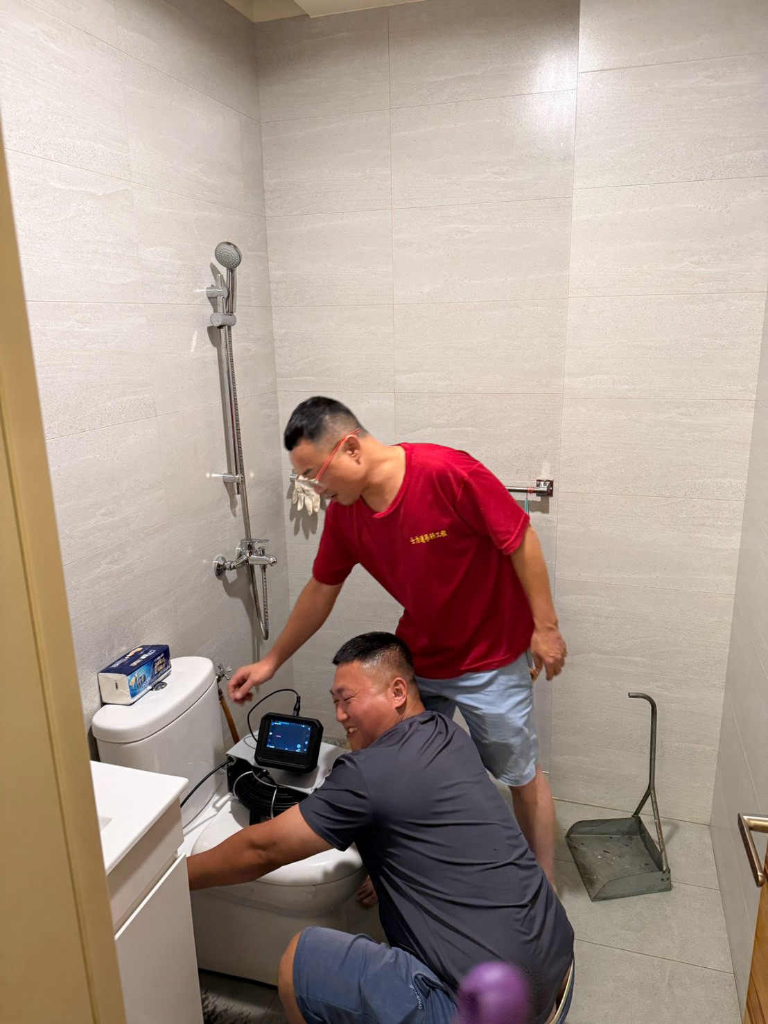 士力達兩位施工人員在浴室使用內視鏡檢查管線